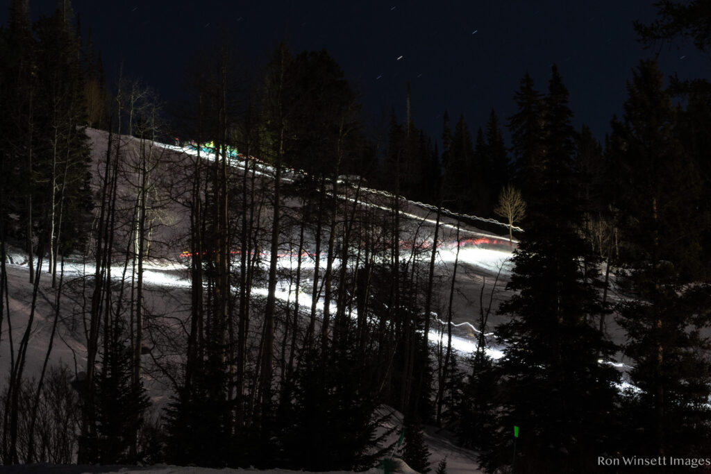 Long exposure of a lot of ski racers moving uphill in a z-shape skintrack
