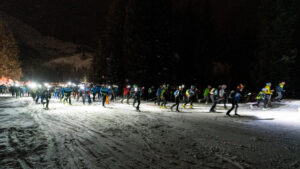 Picture of skimo racers moving up a hill at night.